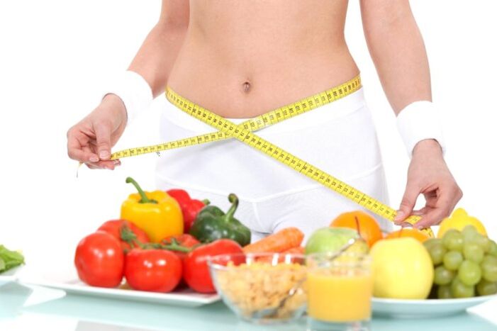 a girl measures her waist on the background of food products